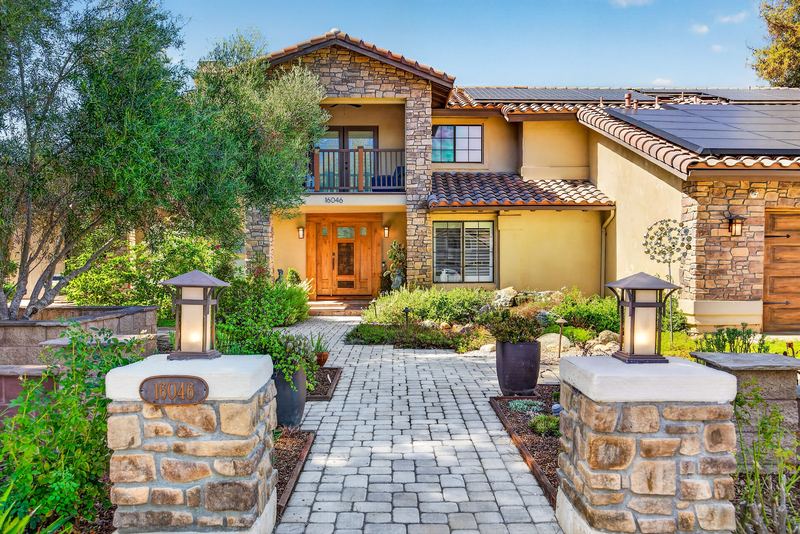 Paver walkway and stone pillars leading to the front door