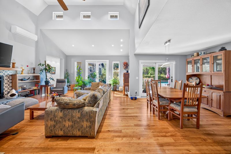 Open living and dining area under a vaulted ceiling